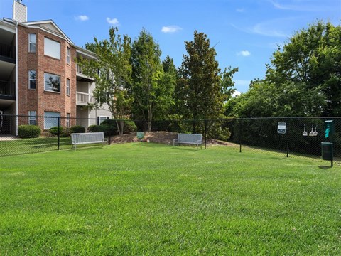 Birmingham, AL apartment complex leash-free dog park with silver sitting benches and black fencing at Chace Lake Villas